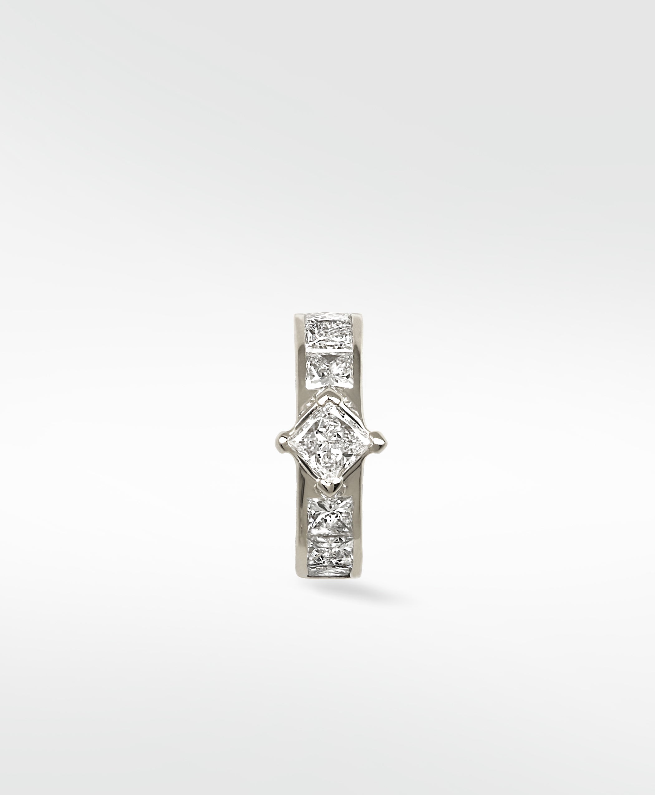 A 14k white gold hoop earring featuring a central princess-cut diamond, flanked by smaller channel-set princess-cut diamonds.