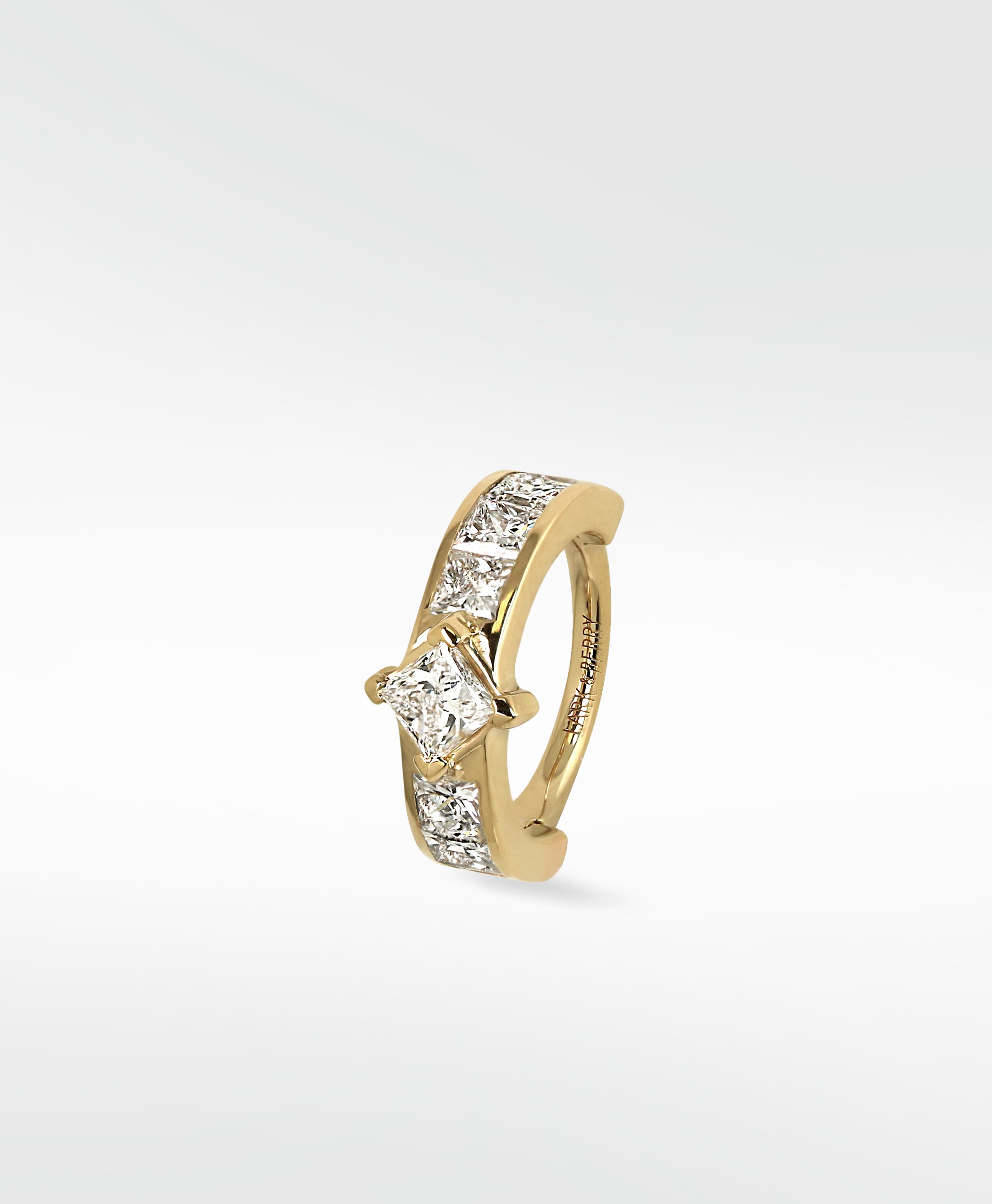 Lark & Berry's Modernist hoop in 14k gold with a central princess cut diamond and channel-set diamond accents.