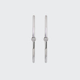 A pair of minimalist Odyssey Silver Hoops, each featuring a single bezel-set diamond on the front-facing side.