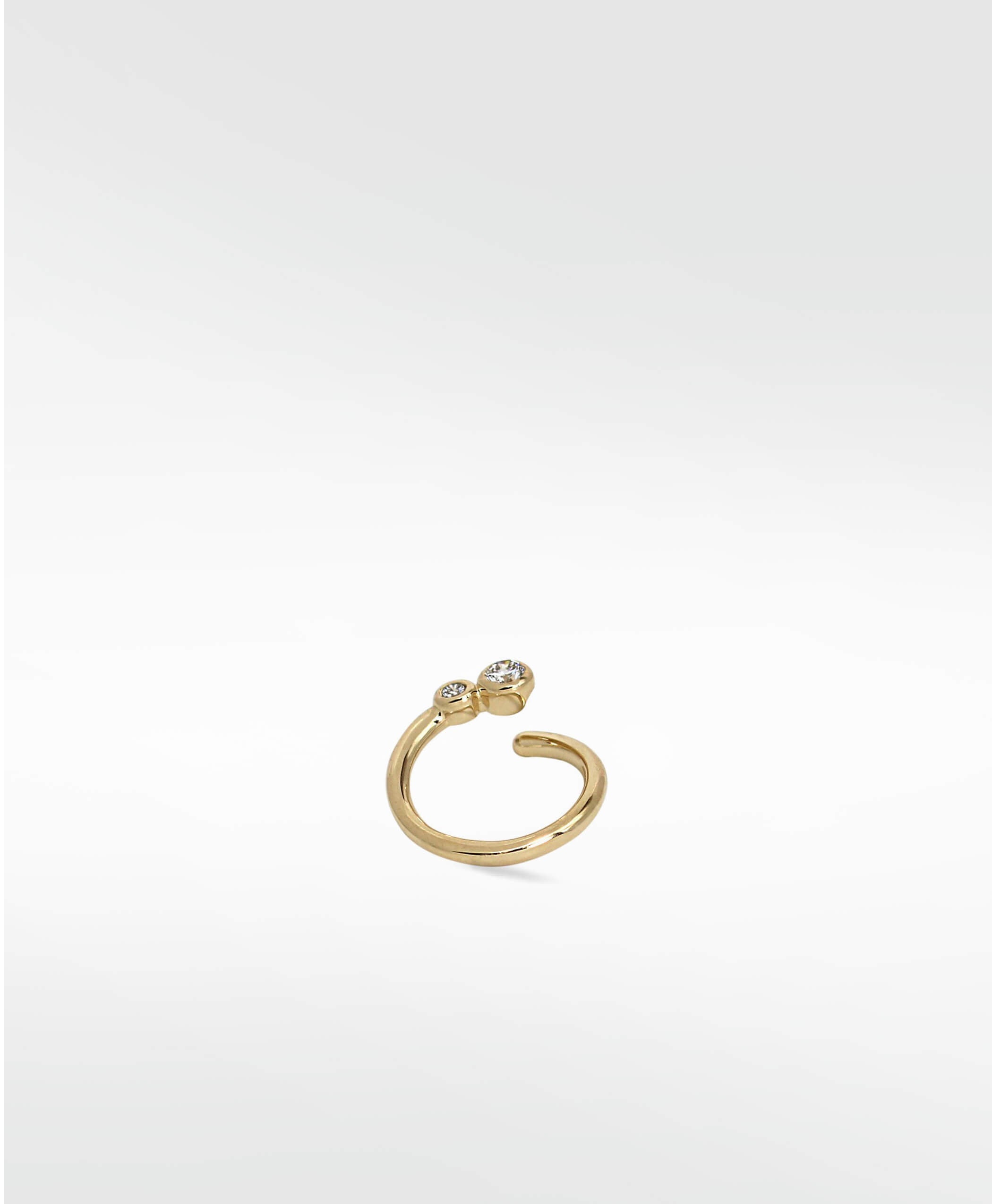 A delicate yellow gold open hoop earring, the Nocturnal Curative Hoop, featuring two bezel-set diamonds at one end.