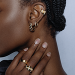 Close-up of a model wearing the gold Palm Diamond Ear Cuff, styled with matching gold diamond rings and hoop earrings.